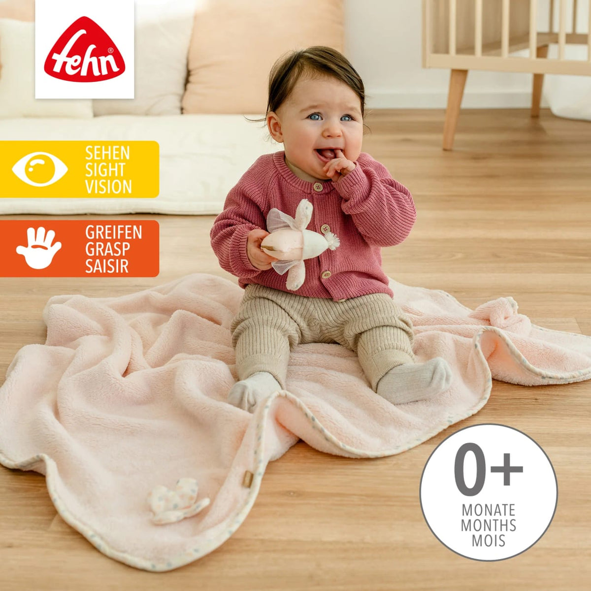 Zdjęcie poglądowe Fehn feehnLAND Vogel – siedzące dziecko z różowym kocykiem