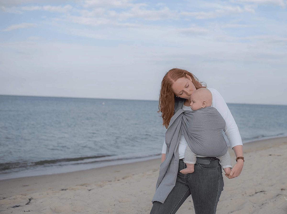 AMAZONAS chusta kółkowa do noszenia dziecka, szara, mama nosi niemowlę na plaży
