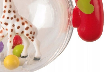 Zbliżenie figurki żyrafy i kolorowych kuleczek wewnątrz grzechotki Sophie la girafe.