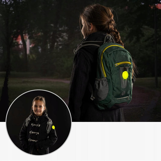 Reer Light and Go lampka zawieszona na plecaku po zmroku